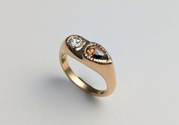 Gold ring with gemstones on a light gray background